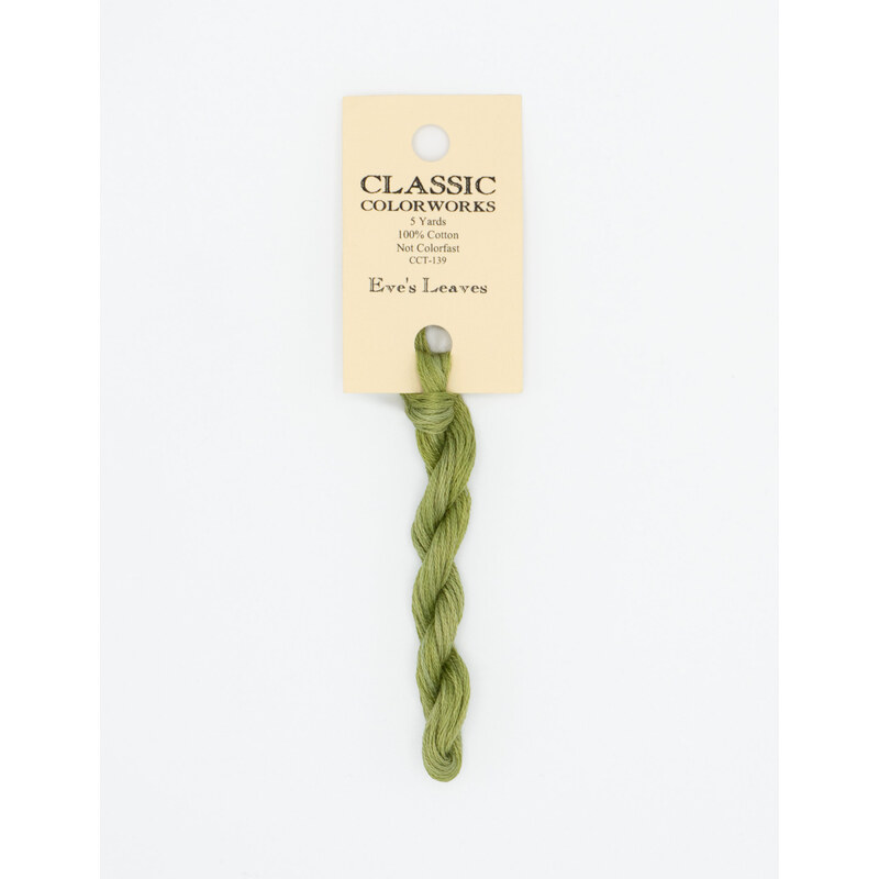 A skein of light leaf green embroidery floss, twisted and bundled, with a cream and black label featuring the brand name and color information.