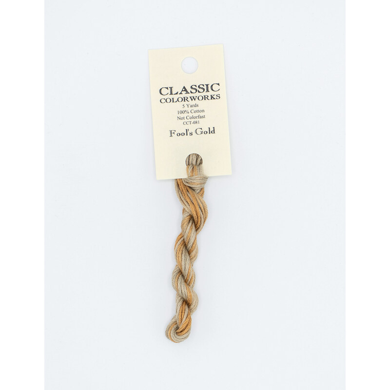 A skein of variegated gray and nut brown embroidery floss, twisted and bundled, with a cream and black label featuring the brand name and color information.