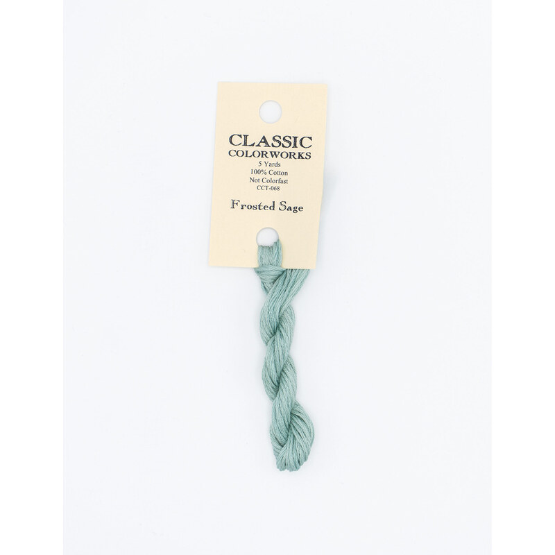 A skein of ice blue embroidery floss, twisted and bundled, with a cream and black label featuring the brand name and color information.