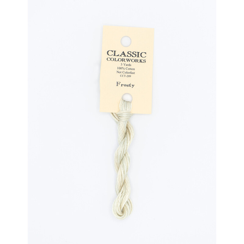 A skein of white embroidery floss, twisted and bundled, with a cream and black label featuring the brand name and color information.