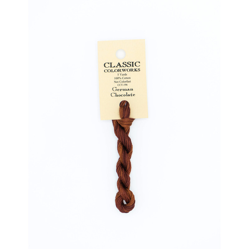 A skein of dark brown embroidery floss, twisted and bundled, with a cream and black label featuring the brand name and color information.
