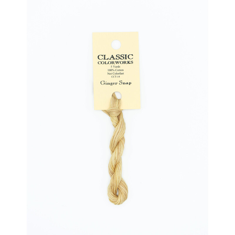 A skein of yellow embroidery floss, twisted and bundled, with a cream and black label featuring the brand name and color information.