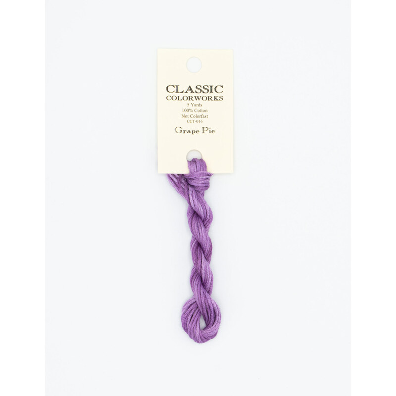 A skein of purple embroidery floss, twisted and bundled, with a cream and black label featuring the brand name and color information.