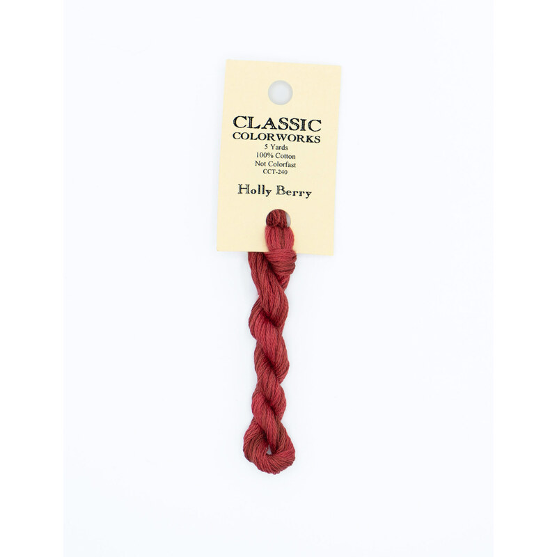 A skein of red embroidery floss, twisted and bundled, with a cream and black label featuring the brand name and color information.