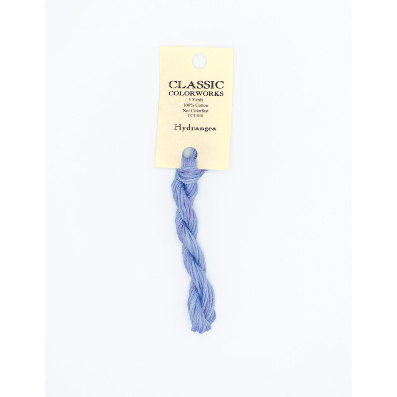 A skein of powder blue embroidery floss, twisted and bundled, with a cream and black label featuring the brand name and color information.