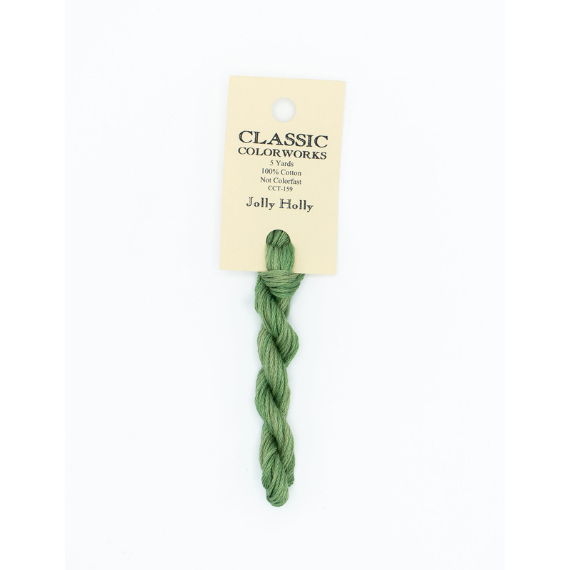 A skein of green embroidery floss, twisted and bundled, with a cream and black label featuring the brand name and color information.