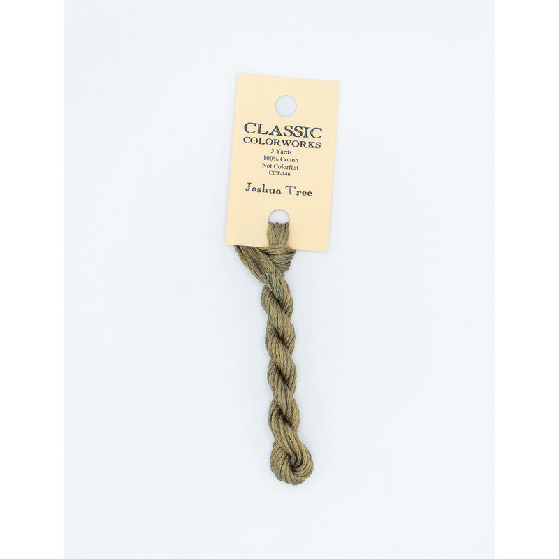 A skein of light sage green embroidery floss, twisted and bundled, with a cream and black label featuring the brand name and color information.