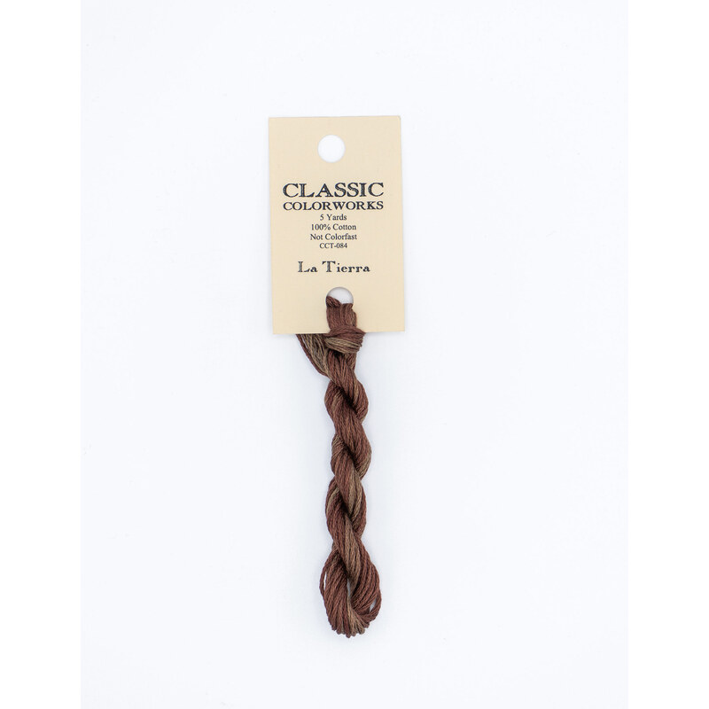 A skein of variegated brown embroidery floss, twisted and bundled, with a cream and black label featuring the brand name and color information.
