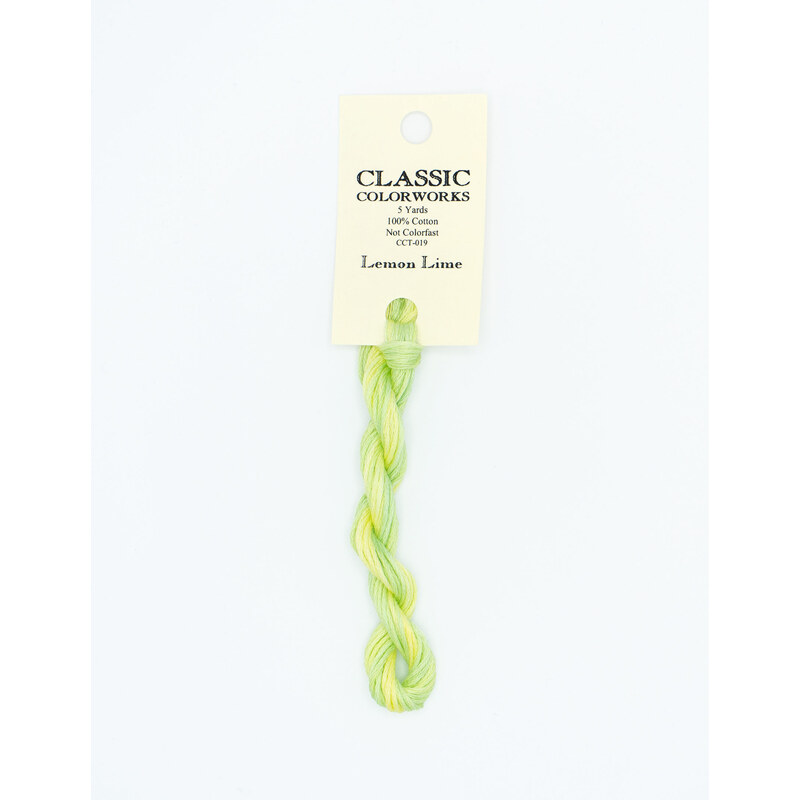 A skein of light green embroidery floss, twisted and bundled, with a cream and black label featuring the brand name and color information.