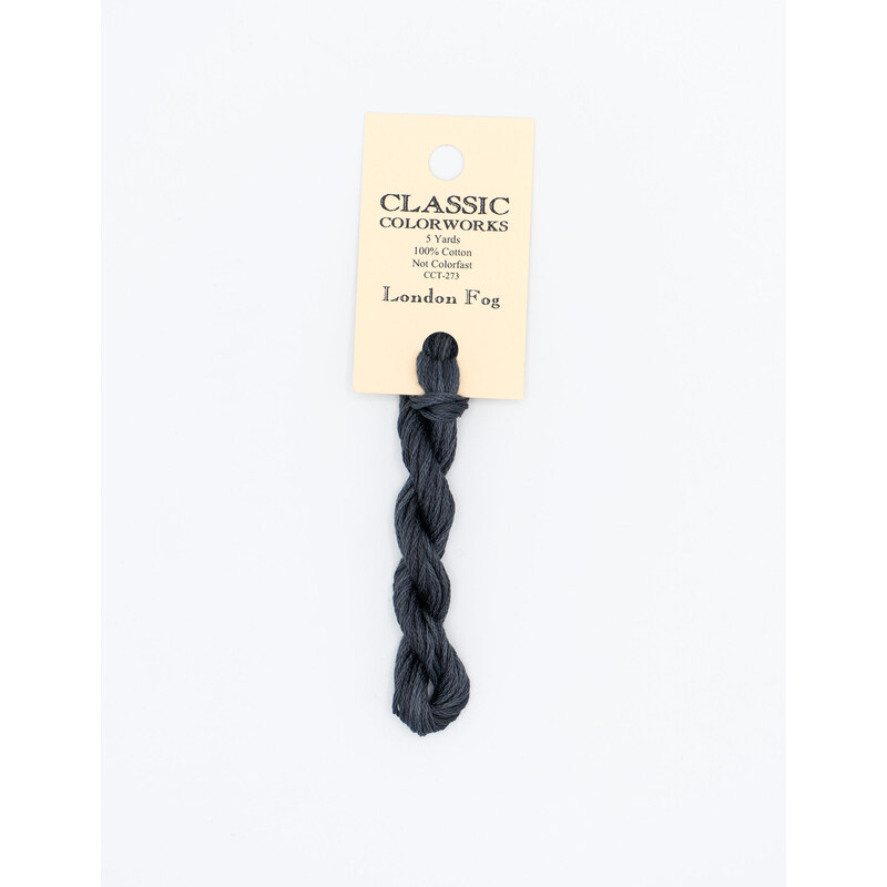 A skein of soft black embroidery floss, twisted and bundled, with a cream and black label featuring the brand name and color information.