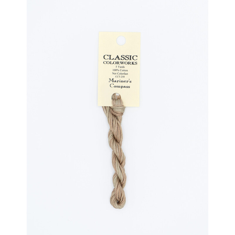 A skein of tan embroidery floss, twisted and bundled, with a cream and black label featuring the brand name and color information.