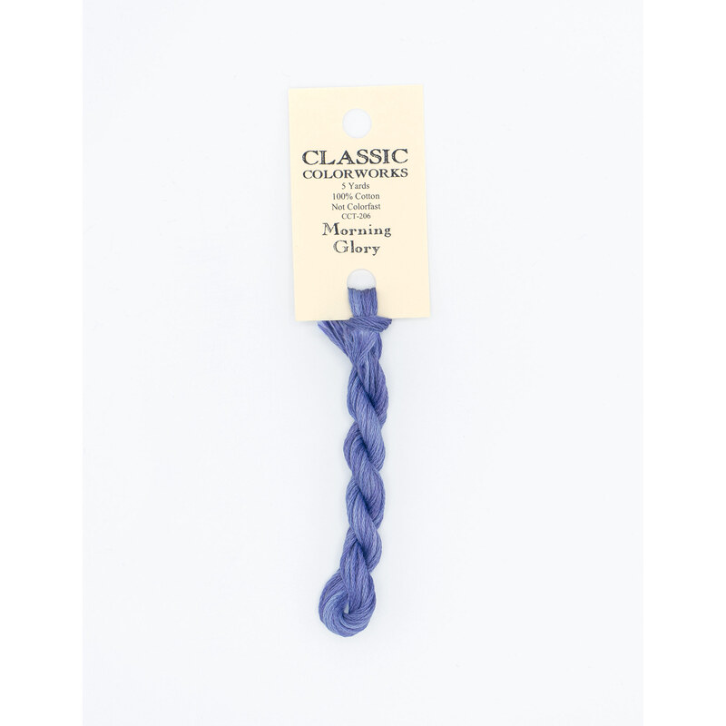 A skein of cornflower blue embroidery floss, twisted and bundled, with a cream and black label featuring the brand name and color information.