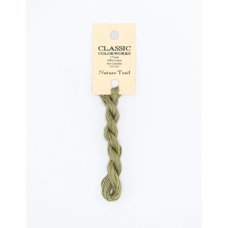 A skein of olive green embroidery floss, twisted and bundled, with a cream and black label featuring the brand name and color information.