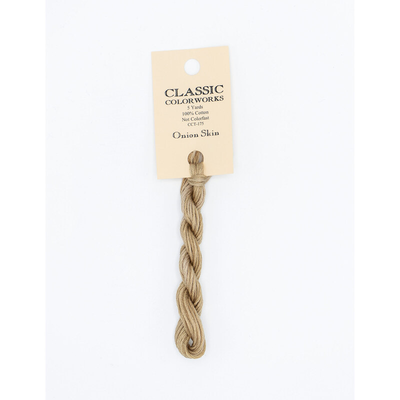 A skein of tan embroidery floss, twisted and bundled, with a cream and black label featuring the brand name and color information.