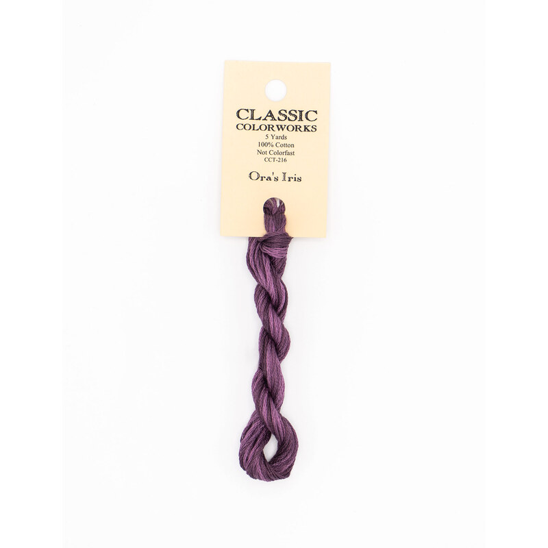 A skein of purple embroidery floss, twisted and bundled, with a cream and black label featuring the brand name and color information.