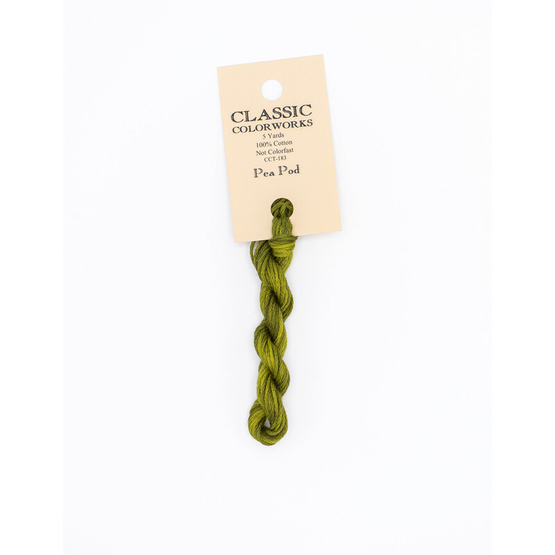 A skein of green embroidery floss, twisted and bundled, with a cream and black label featuring the brand name and color information.