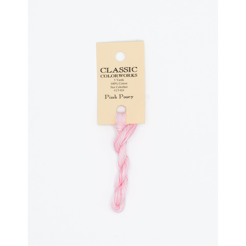 A skein of pastel pink embroidery floss, twisted and bundled, with a cream and black label featuring the brand name and color information.