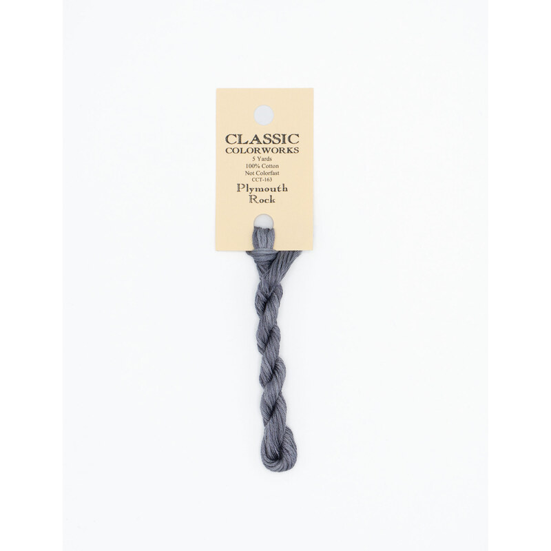 A skein of dark gray embroidery floss, twisted and bundled, with a cream and black label featuring the brand name and color information.