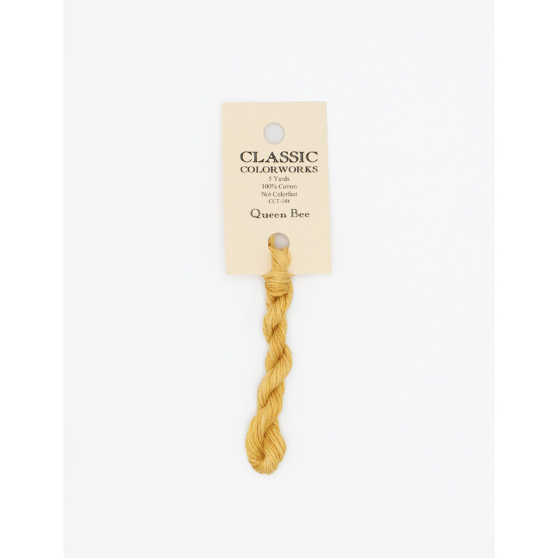 A skein of honey yellow embroidery floss, twisted and bundled, with a cream and black label featuring the brand name and color information.