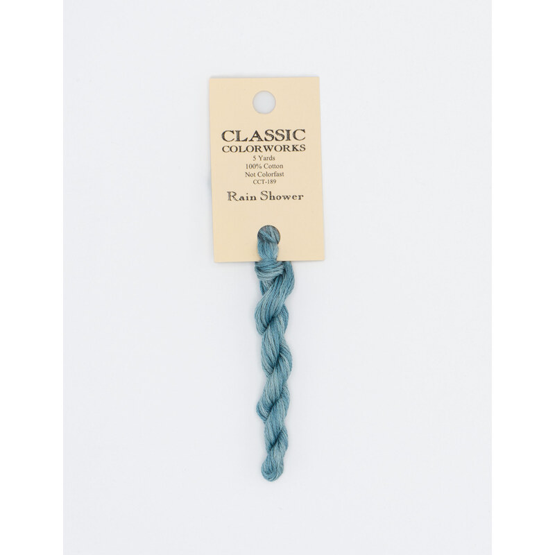 A skein of powder blue embroidery floss, twisted and bundled, with a cream and black label featuring the brand name and color information.