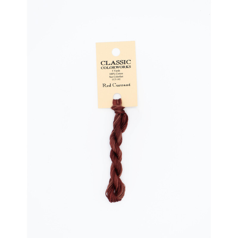 A skein of red embroidery floss, twisted and bundled, with a cream and black label featuring the brand name and color information.