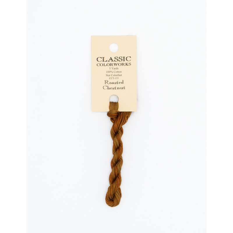 A skein of burnt sienna embroidery floss, twisted and bundled, with a cream and black label featuring the brand name and color information.