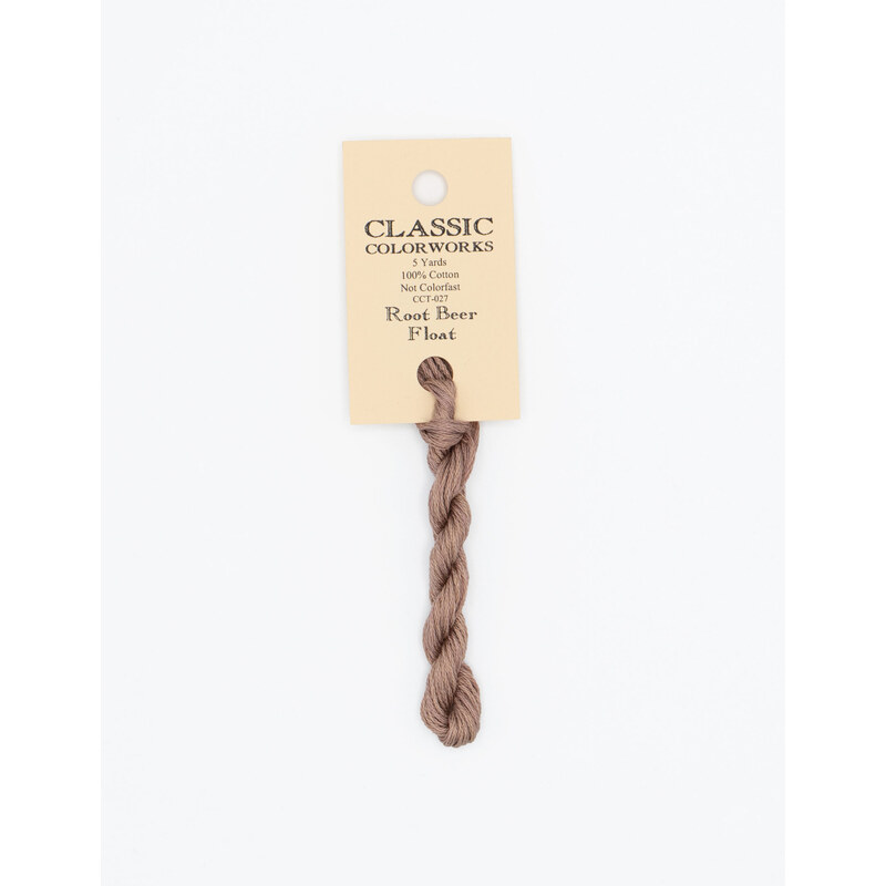 A skein of dusty mauve embroidery floss, twisted and bundled, with a cream and black label featuring the brand name and color information.