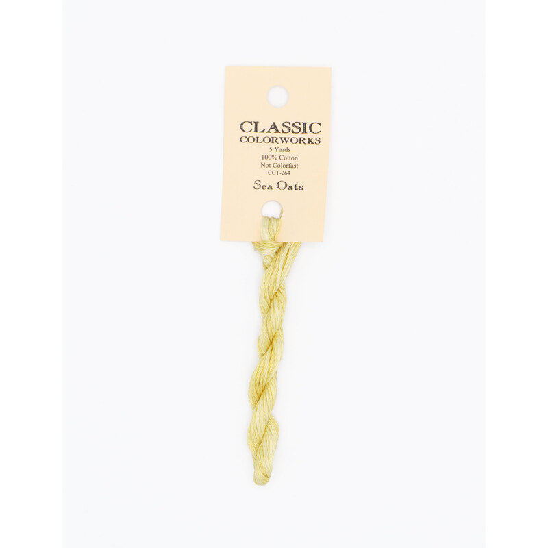 A skein of yellow embroidery floss, twisted and bundled, with a cream and black label featuring the brand name and color information.