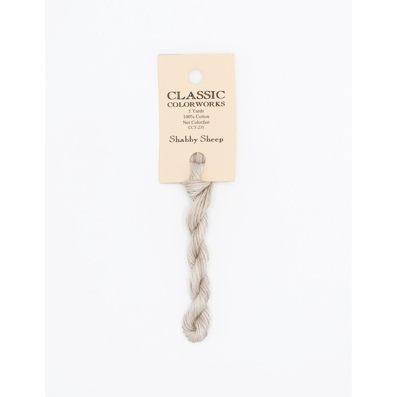 A skein of gray cream embroidery floss, twisted and bundled, with a cream and black label featuring the brand name and color information.