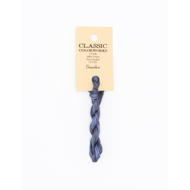 A skein of dark gray embroidery floss, twisted and bundled, with a cream and black label featuring the brand name and color information.