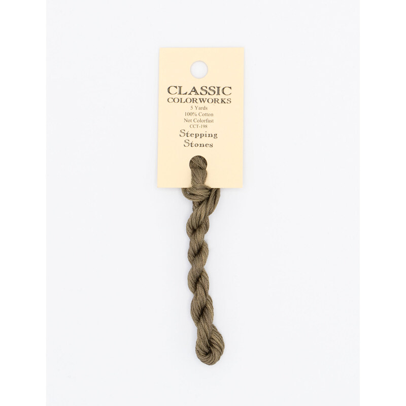 A skein of brown embroidery floss, twisted and bundled, with a cream and black label featuring the brand name and color information.