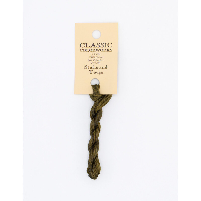 A skein of brown embroidery floss, twisted and bundled, with a cream and black label featuring the brand name and color information.