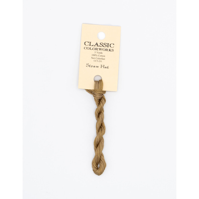 A skein of brown embroidery floss, twisted and bundled, with a cream and black label featuring the brand name and color information.