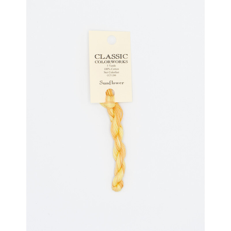 A skein of bright yellow embroidery floss, twisted and bundled, with a cream and black label featuring the brand name and color information.