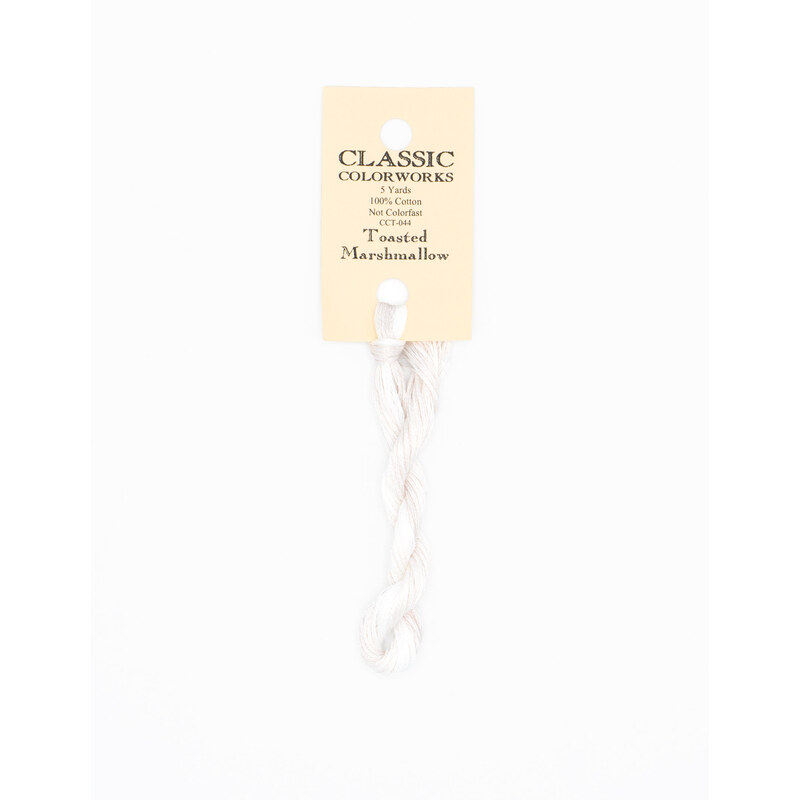 A skein of white embroidery floss, twisted and bundled, with a cream and black label featuring the brand name and color information.