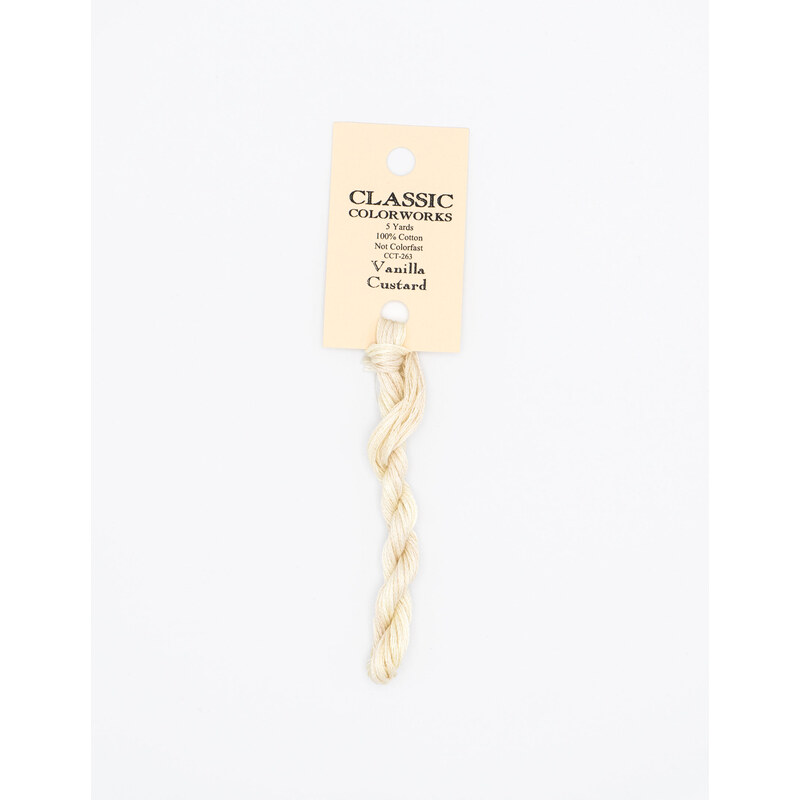 A skein of cream embroidery floss, twisted and bundled, with a cream and black label featuring the brand name and color information.