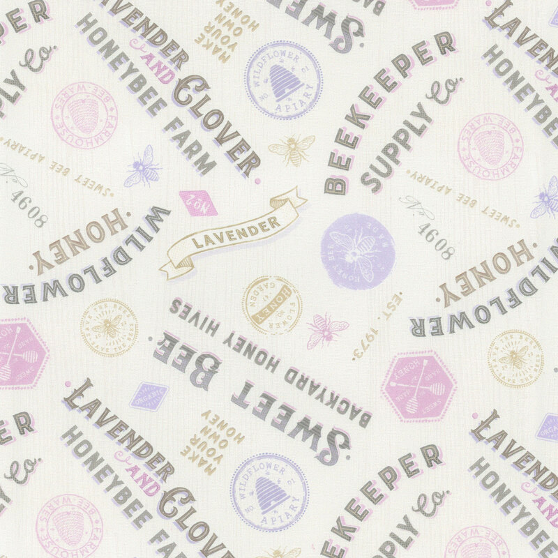 textured white fabric featuring vintage lettered signs and stamps in lilac, lavender, tan, and black.