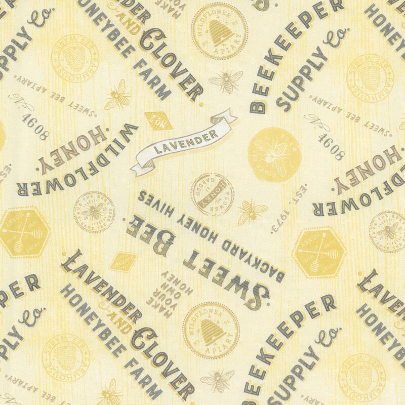 textured yellow fabric featuring vintage lettered signs in black text, yellow stamps, and yellow bees.