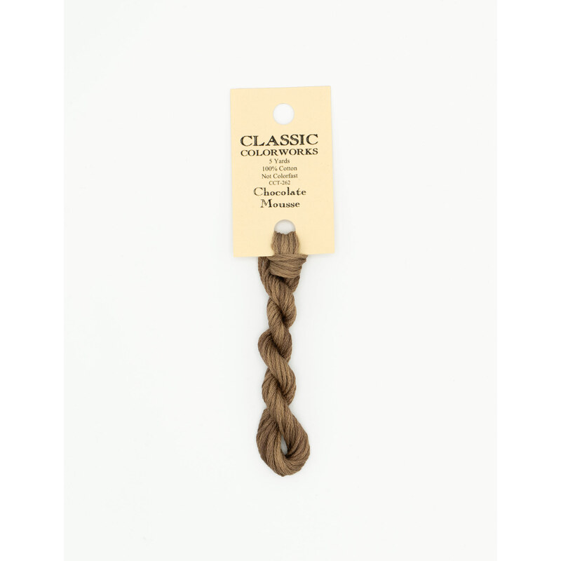 A skein of light chocolate embroidery floss, twisted and bundled, with a cream and black label featuring the brand name and color information.