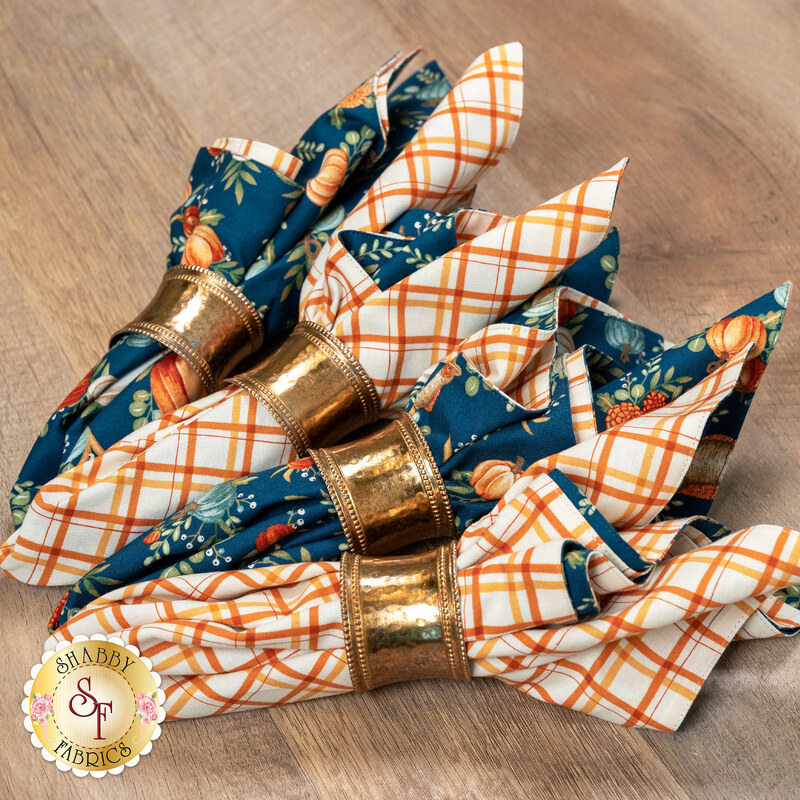 A close up on the cloth napkins in golden rings, demonstrating fabric color and print details.