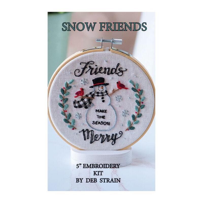 The cover of the hand embroidery kit displaying the completed project: a snowman and two cardinals with the phrase 