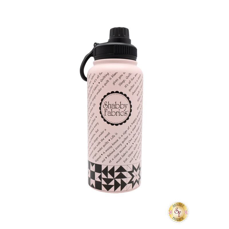 The Shabby Fabrics water bottle in light Shabby pink and contrasting black, isolated on a white background. The logo faces out and patchwork squares line the bottom of the bottle.