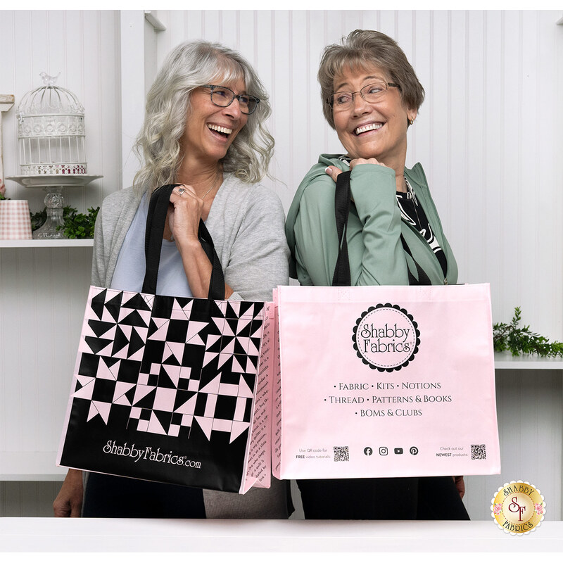 Two smiling models (Lynn and Tammy) demonstrating usage of the pink tote bags.