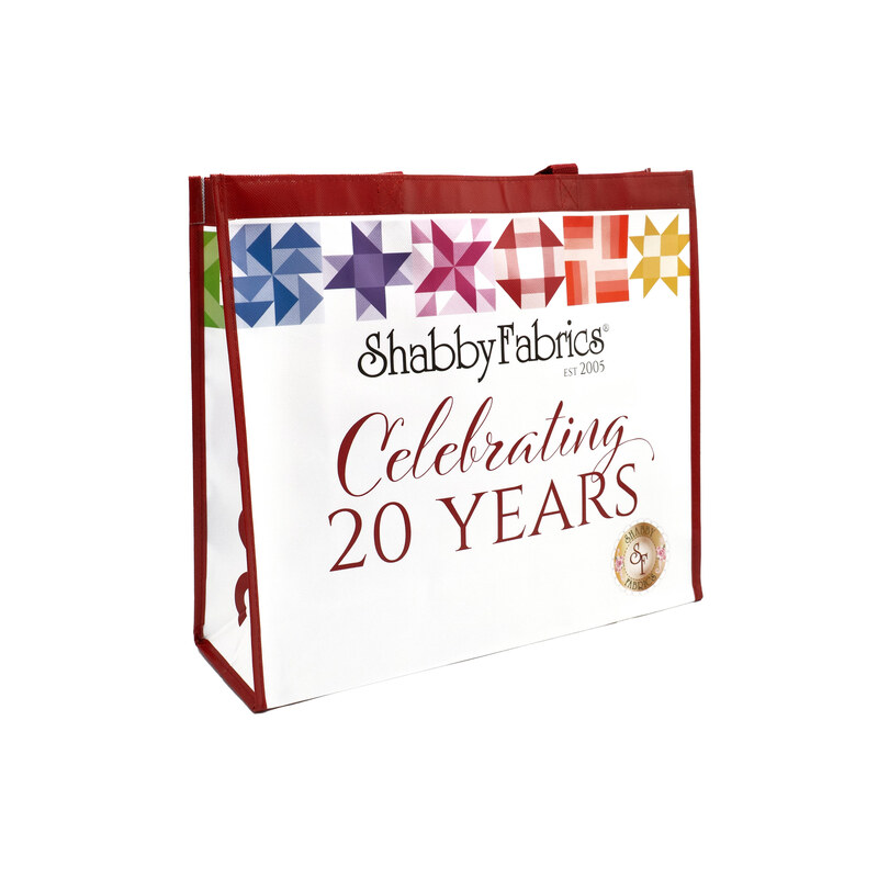 The Shabby Fabrics 20th anniversary tote bag, showing details on the rainbow patchwork block designs and text graphic, isolated on a white background.