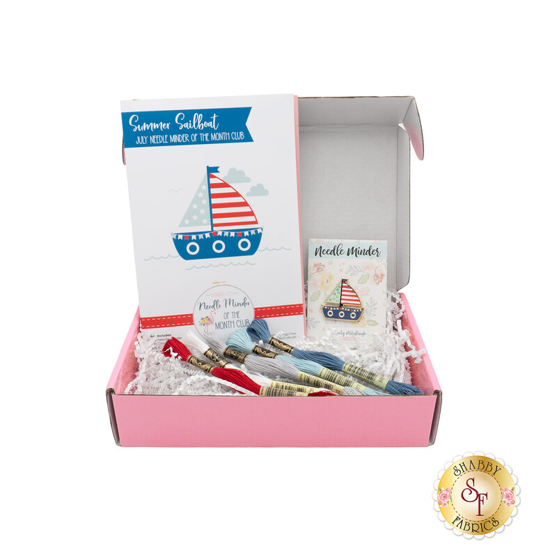 The July Needle Minder of the Month, a red, white, and blue project centered around a needle minder of a patriotic sailboat. 