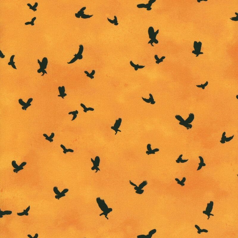 mottled pumpkin-orange fabric tossed with owl silhouettes in flight