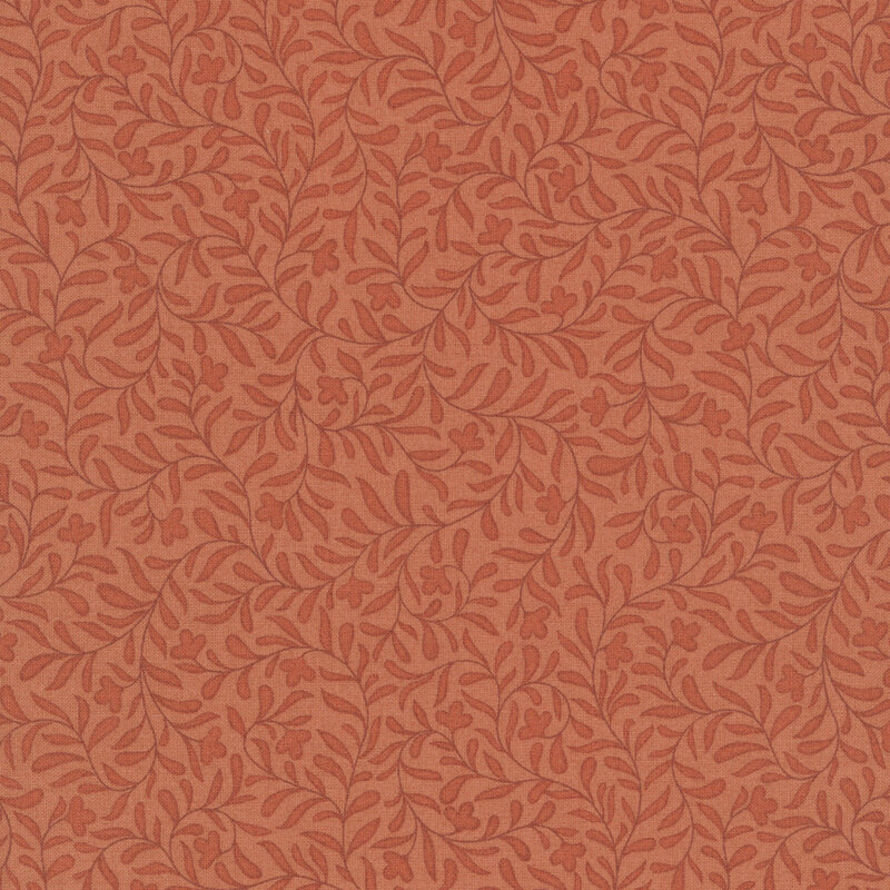 A pumpkin orange fabric with a dense tonal leafy vine design