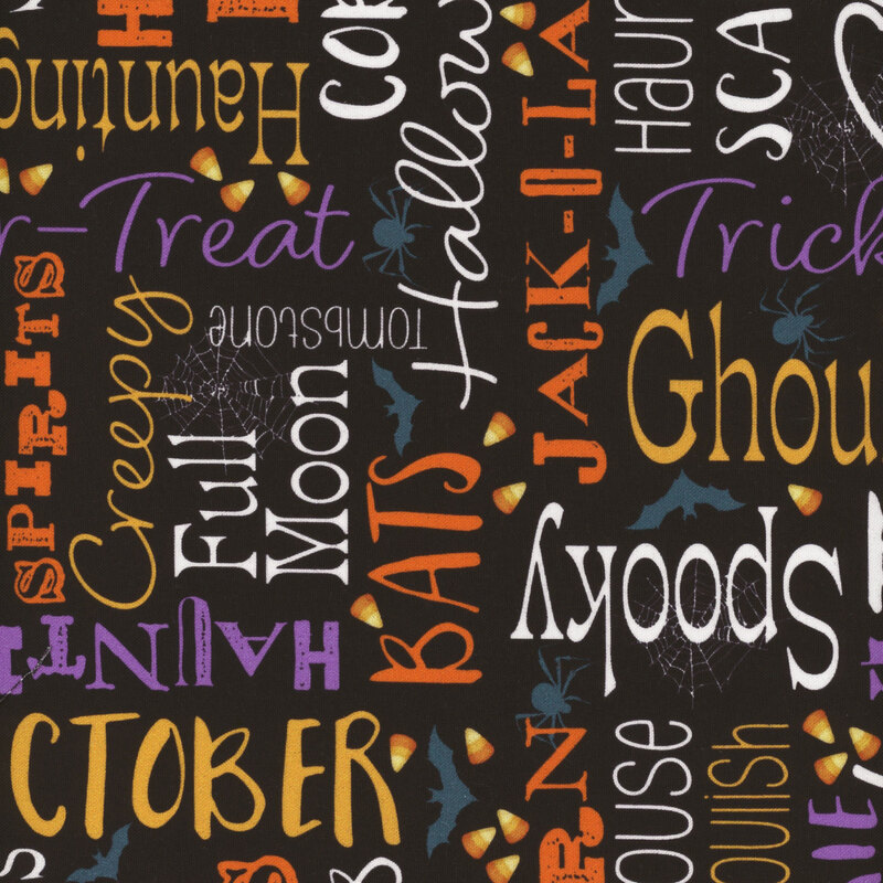 black fabric featuring Halloween-themed words, spider webs, spiders, bats, and candy corn in colors of yellow, orange, purple, and white.