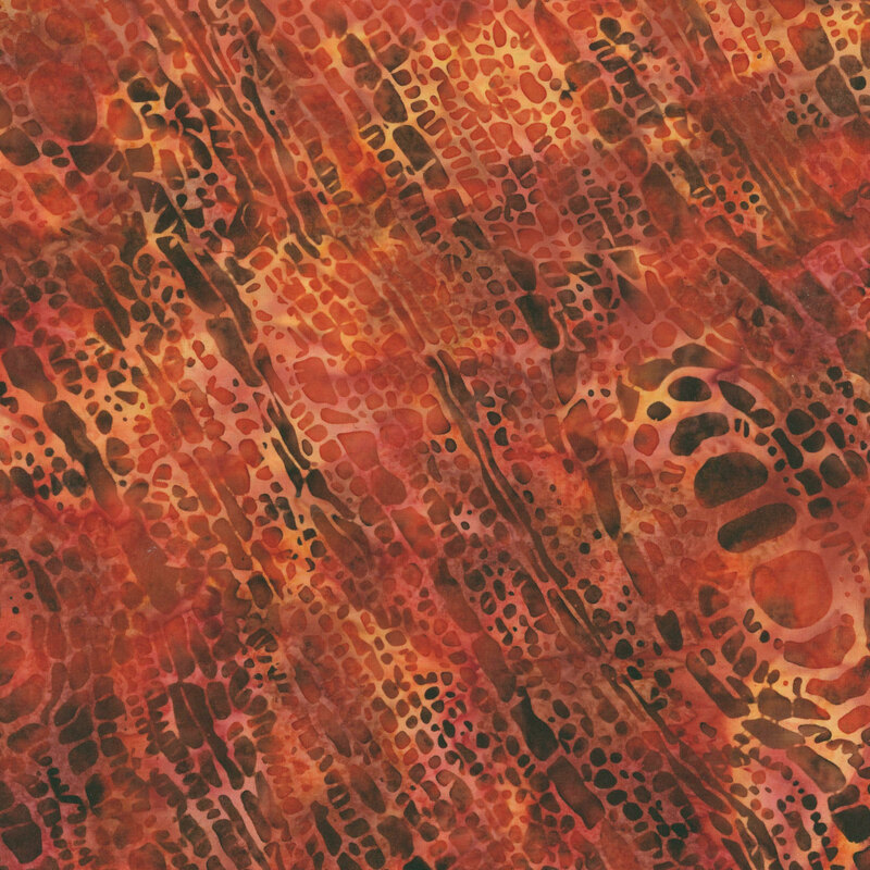 Terra cotta orange batik fabric with a mottled abstract pattern.