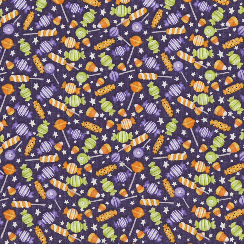 A mottled dark purple fabric with scattered halloween candy. 
